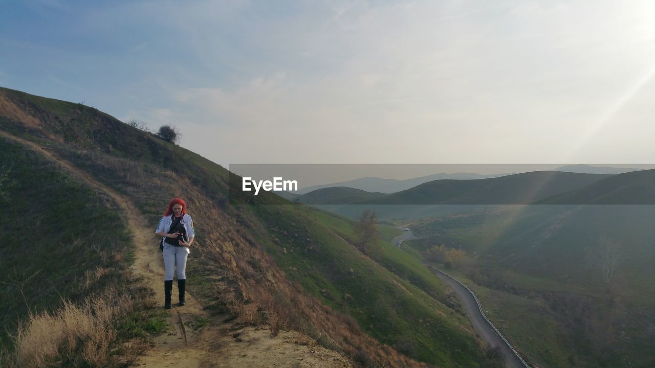 Woman standing on chino hills against sky