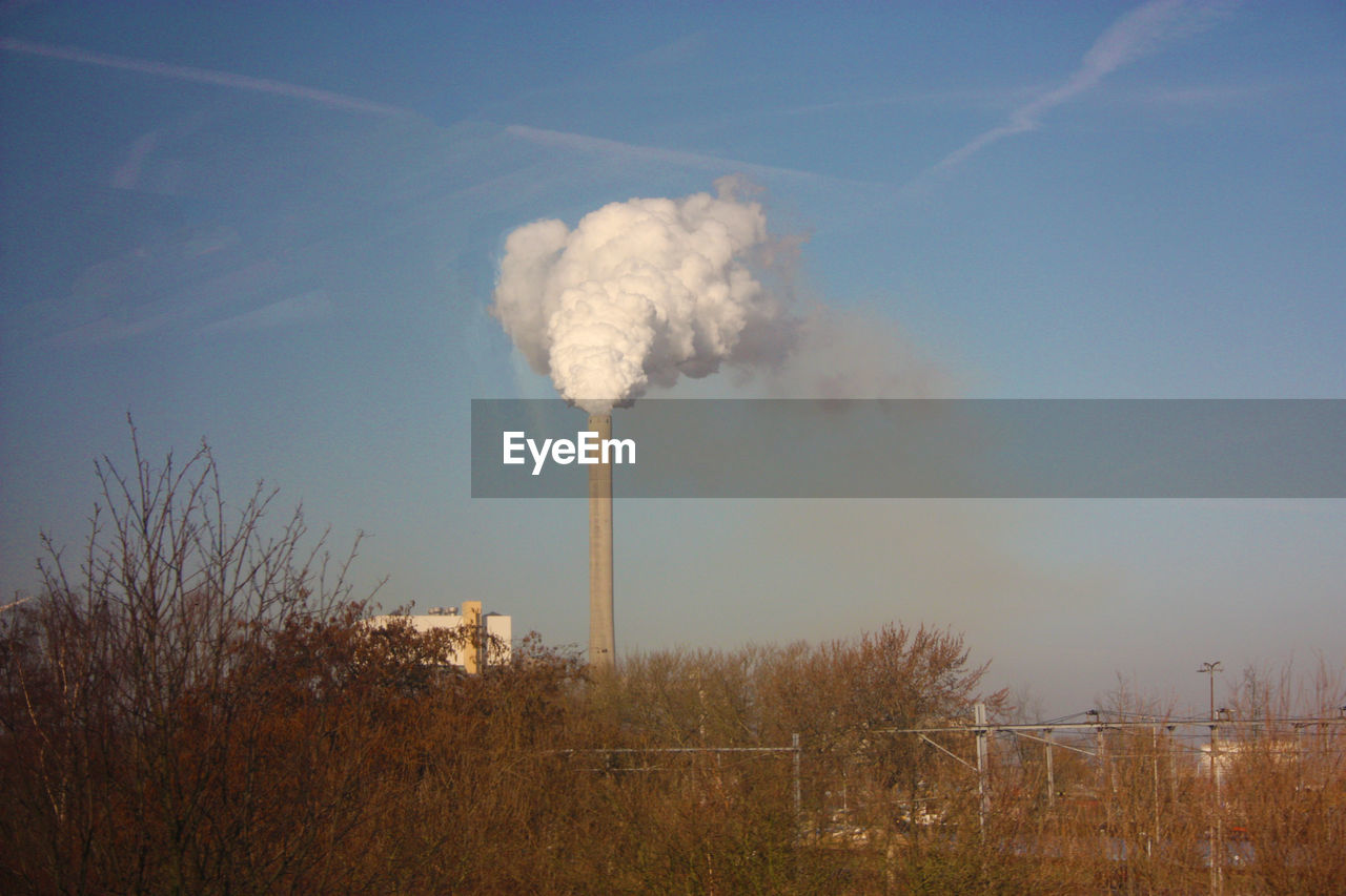 Smoke emitting from chimney against sky