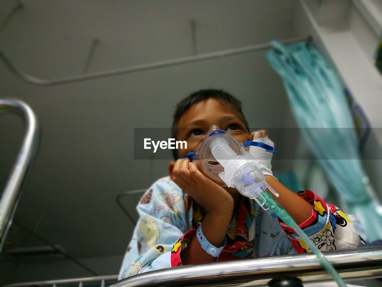 Low angle view of boy with oxygen mask in hospital