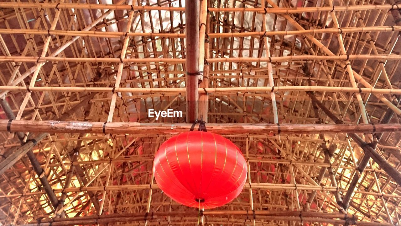 Low angle view of red lantern hanging from bamboo scaffolding