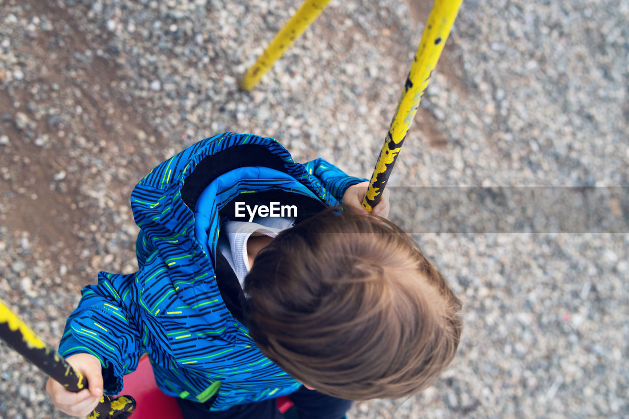 High angle view of boy swinging at playground