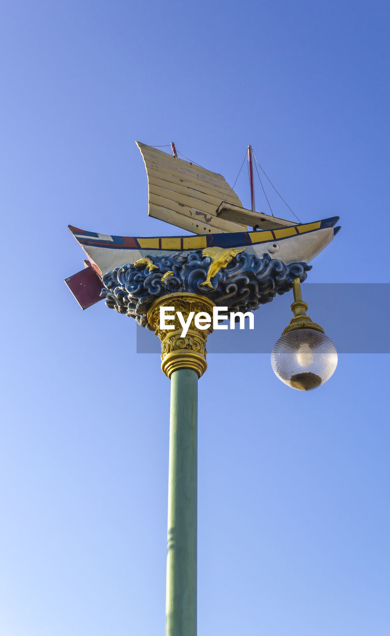 LOW ANGLE VIEW OF TELEPHONE POLE AGAINST CLEAR BLUE SKY