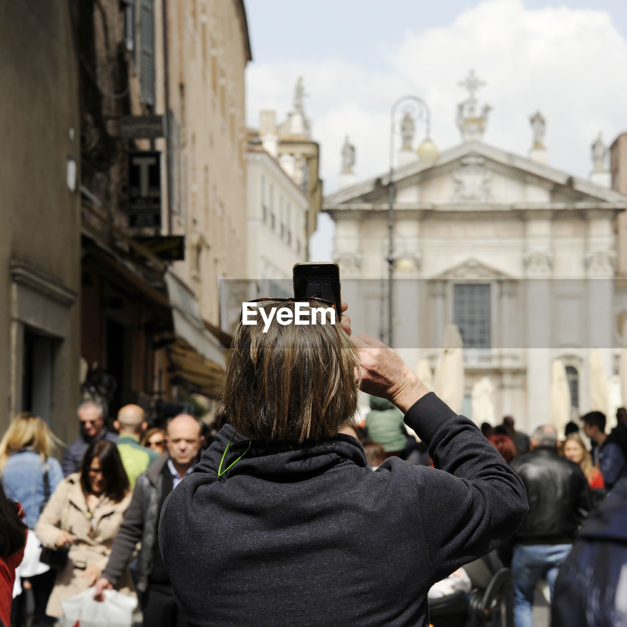 REAR VIEW OF PEOPLE PHOTOGRAPHING AT CITY