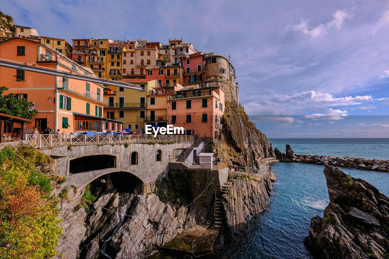 ARCH BRIDGE OVER SEA AND BUILDINGS AGAINST SKY