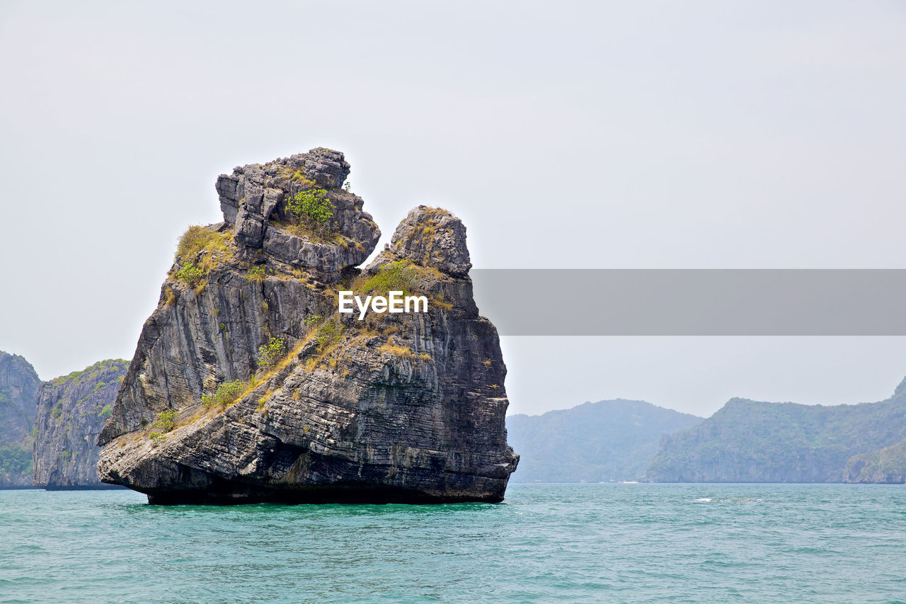 ROCK FORMATIONS IN SEA AGAINST SKY