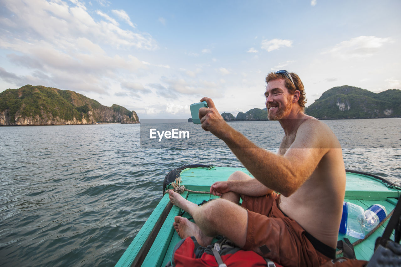 Man taking selfie on a boat at halong bay in vietnam