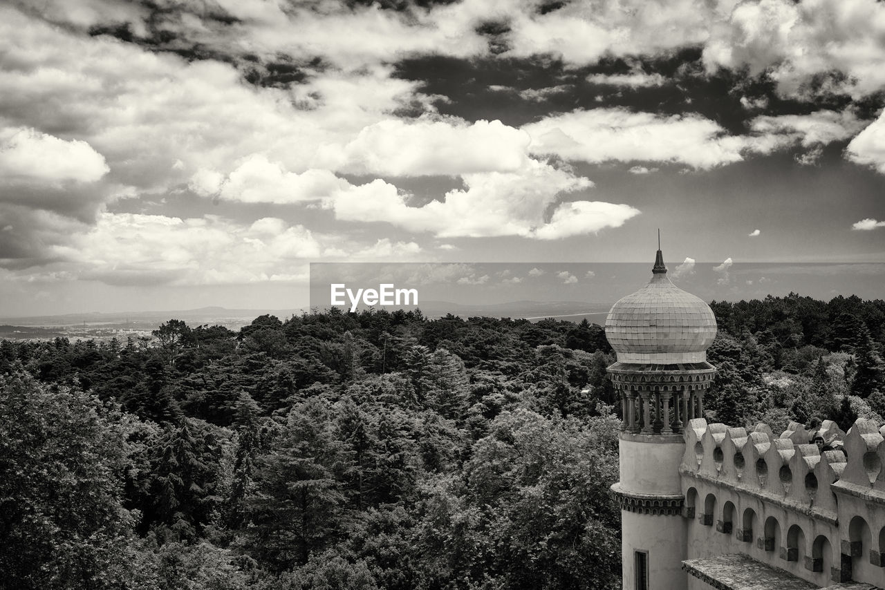 Cropped image of palace by trees against sky