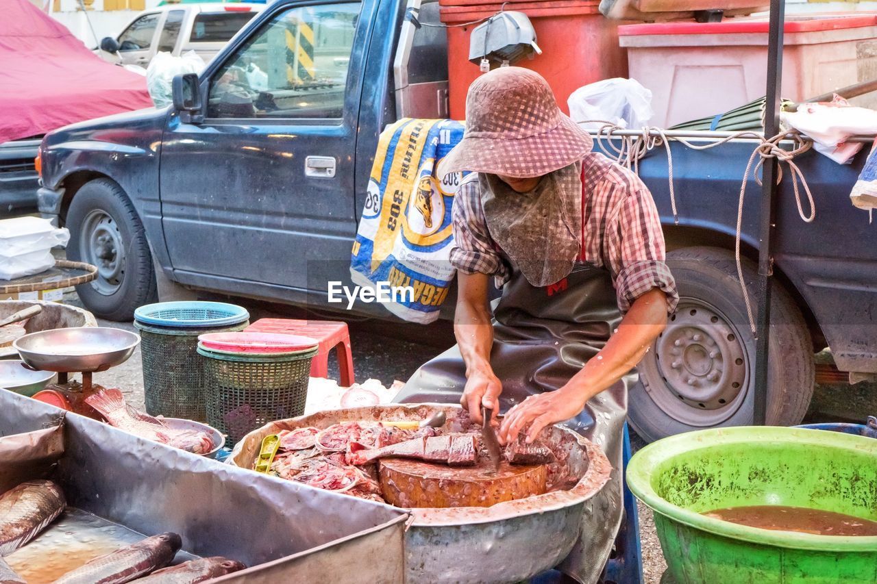 Man cutting fish for sale at market