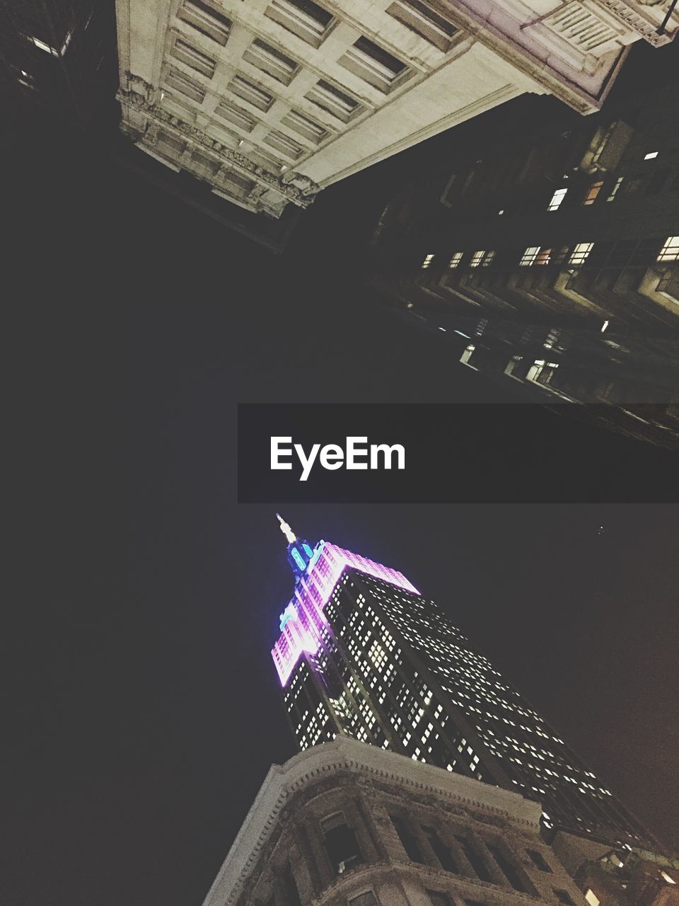 LOW ANGLE VIEW OF SKYSCRAPER AT NIGHT