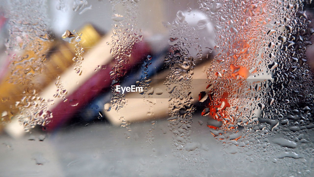 Books seen through wet glass window