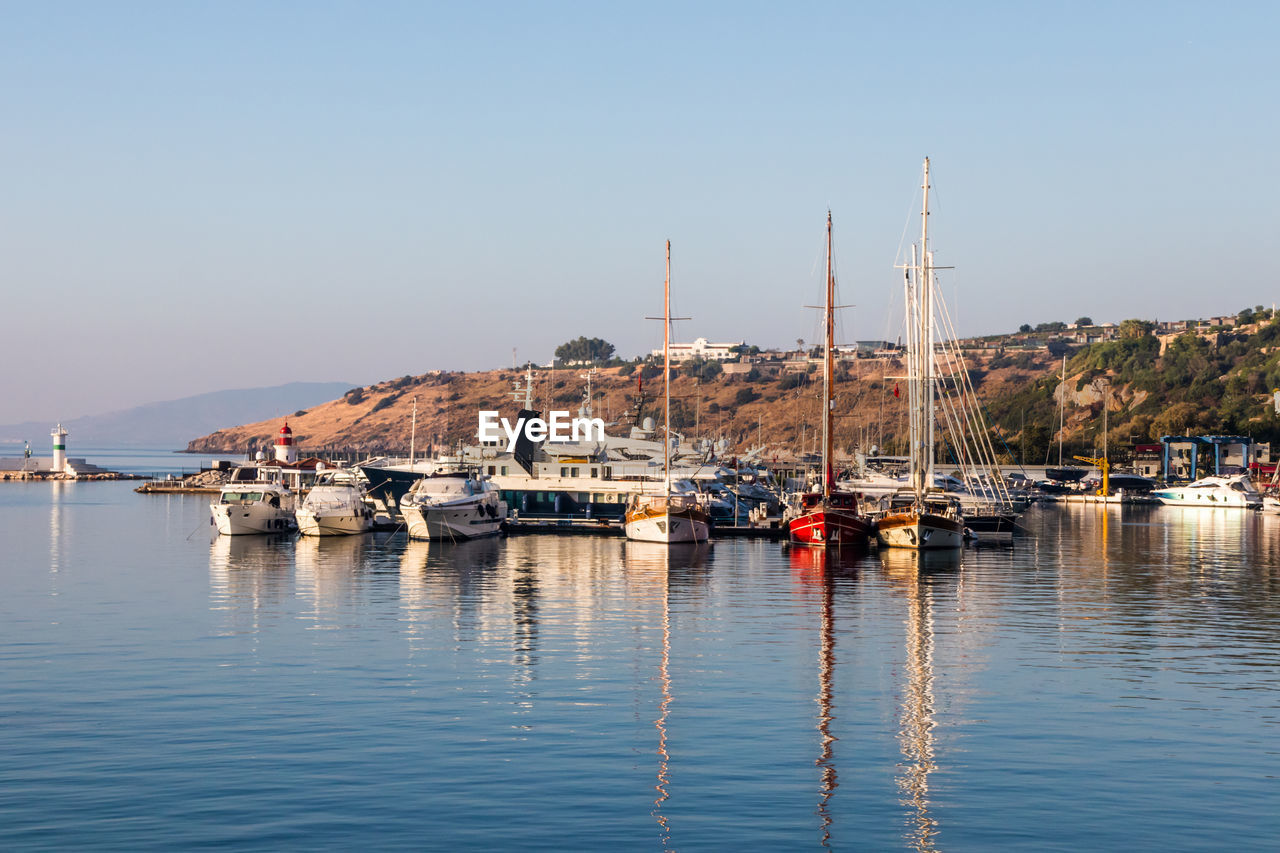 SAILBOATS MOORED IN HARBOR