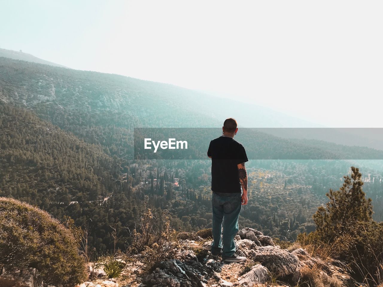 FULL LENGTH REAR VIEW OF MAN STANDING ON MOUNTAIN