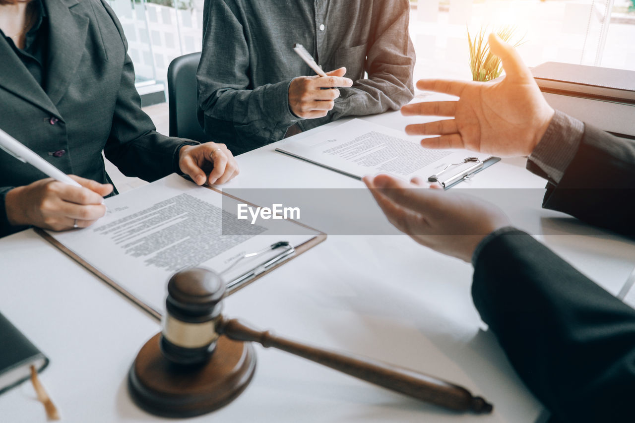 Cropped hands of lawyer gesturing while sitting at desk