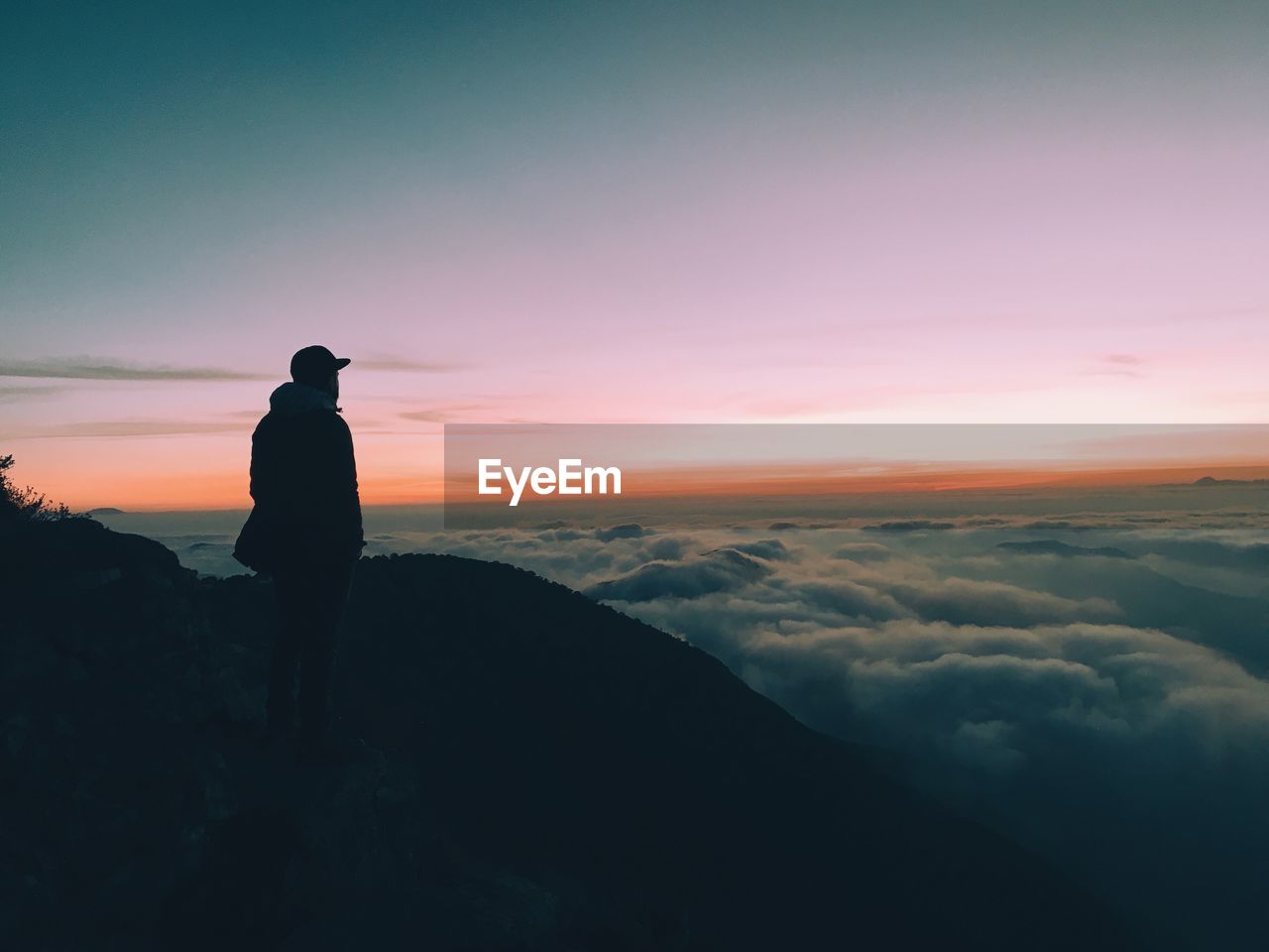 Silhouette man looking at view against sky during sunset