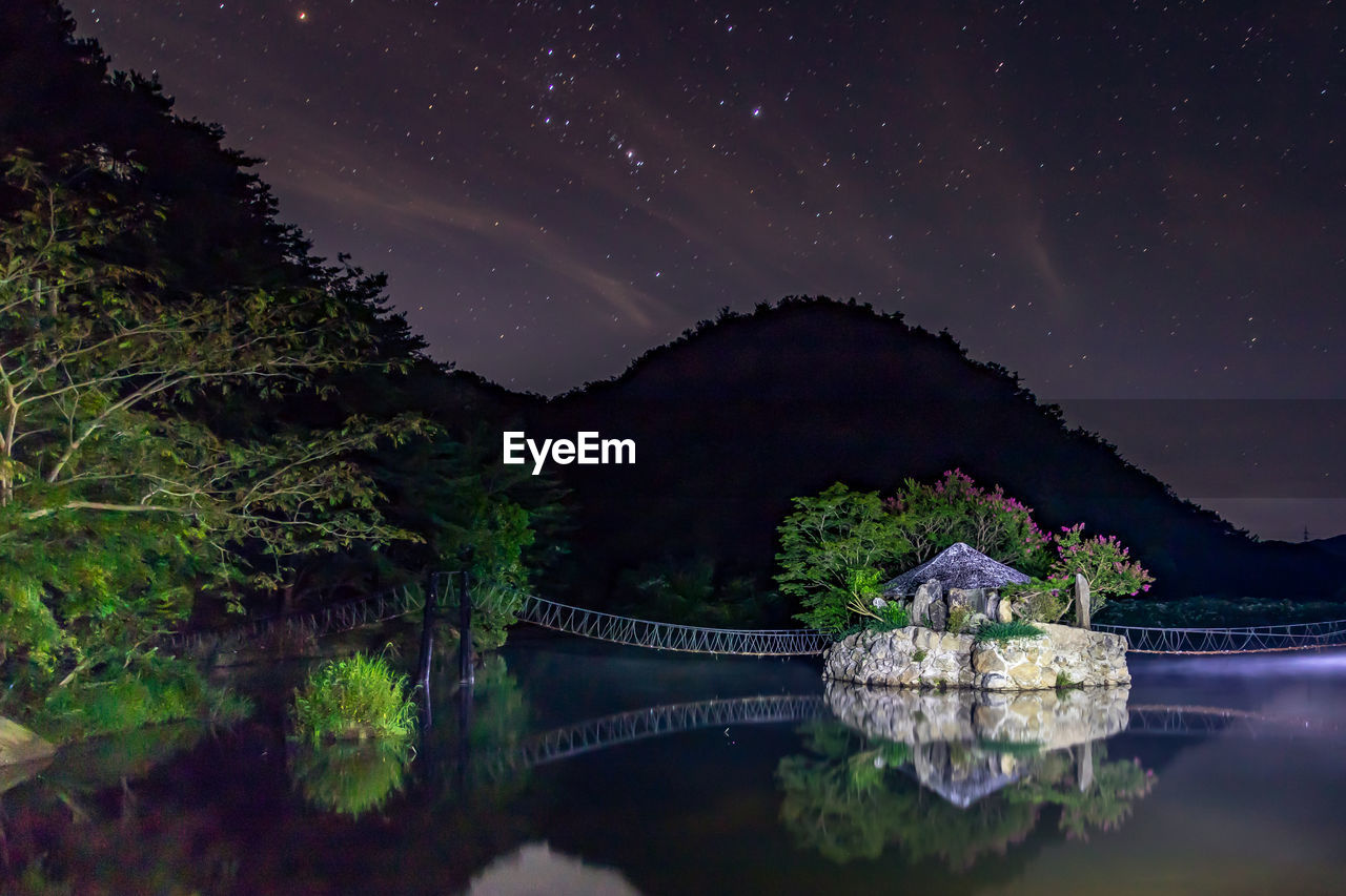 Scenic view of lake against sky at night