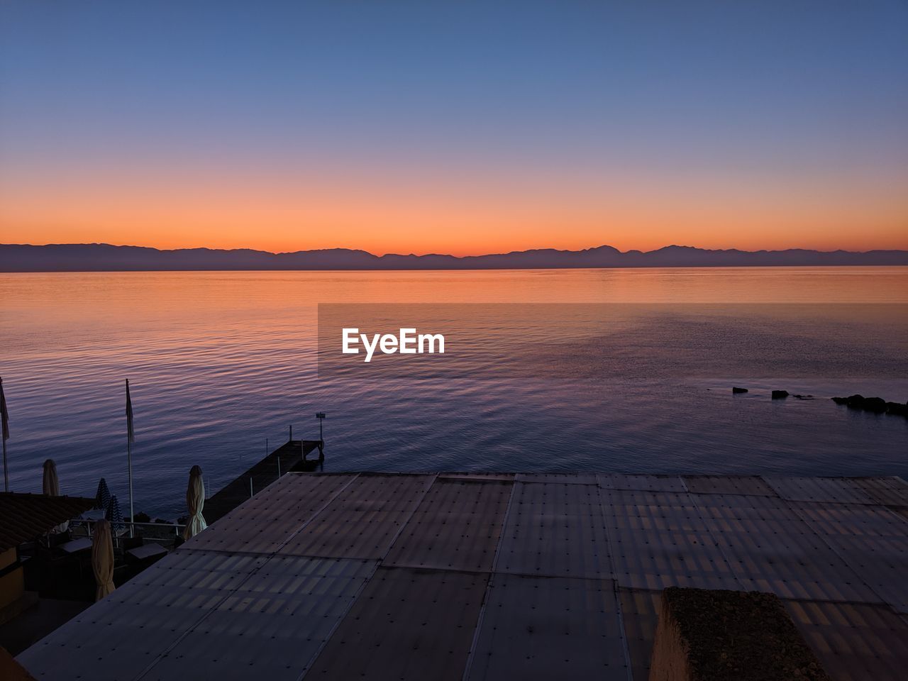 Scenic view of lake against clear sky during sunset