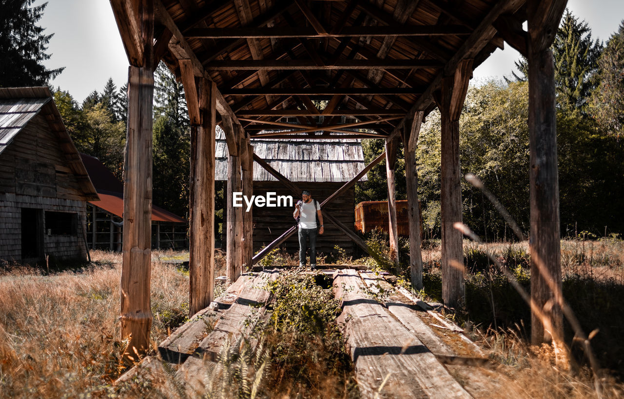 Man standing at abandoned hut 