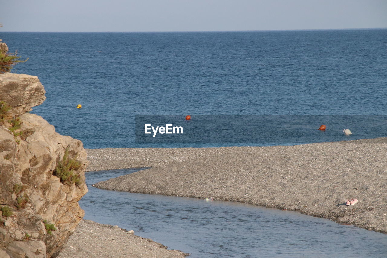 water, sea, shore, coast, scenics - nature, beauty in nature, beach, nature, horizon over water, horizon, land, ocean, sky, body of water, tranquility, tranquil scene, bay, day, cliff, rock, terrain, sand, no people, blue, vacation, outdoors, idyllic, non-urban scene, transportation, high angle view, clear sky