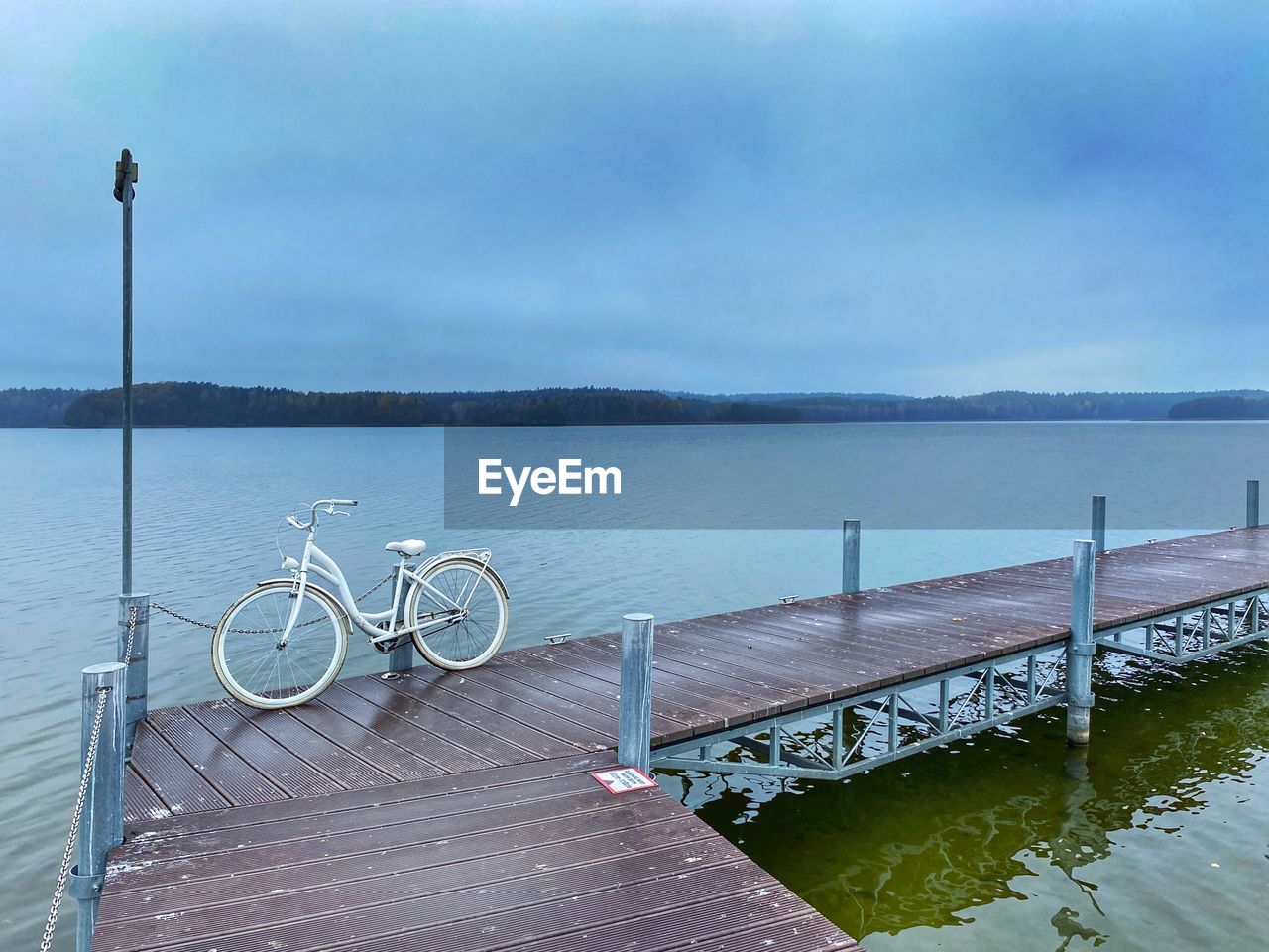 water, bicycle, transportation, vehicle, sky, nature, sea, tranquility, pier, no people, scenics - nature, beauty in nature, tranquil scene, mode of transportation, shore, day, travel, cloud, wood, architecture, environment, dock, beach, outdoors, bicycle wheel, coast, bay, land, travel destinations, railing, absence, jetty, nautical vessel, idyllic, landscape, non-urban scene