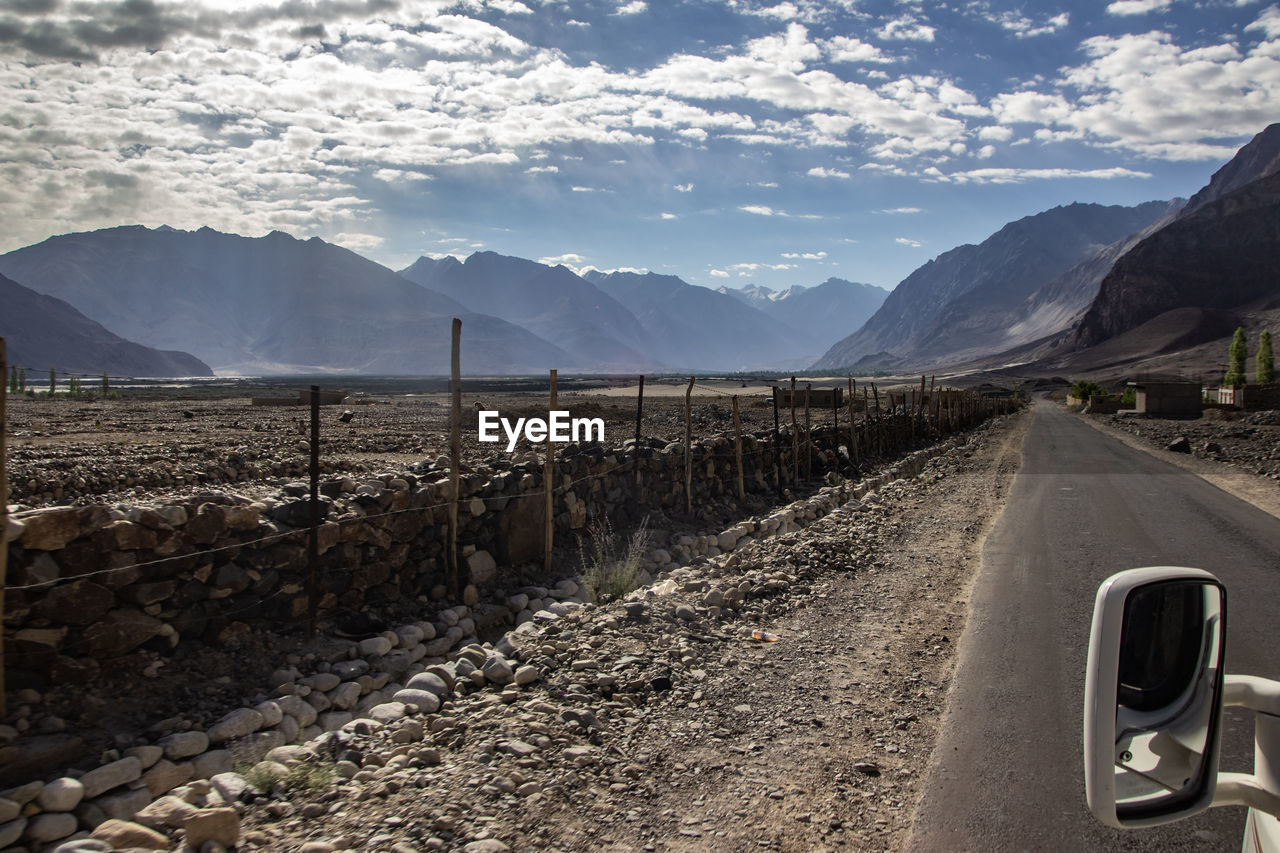 ROAD BY MOUNTAINS AGAINST SKY