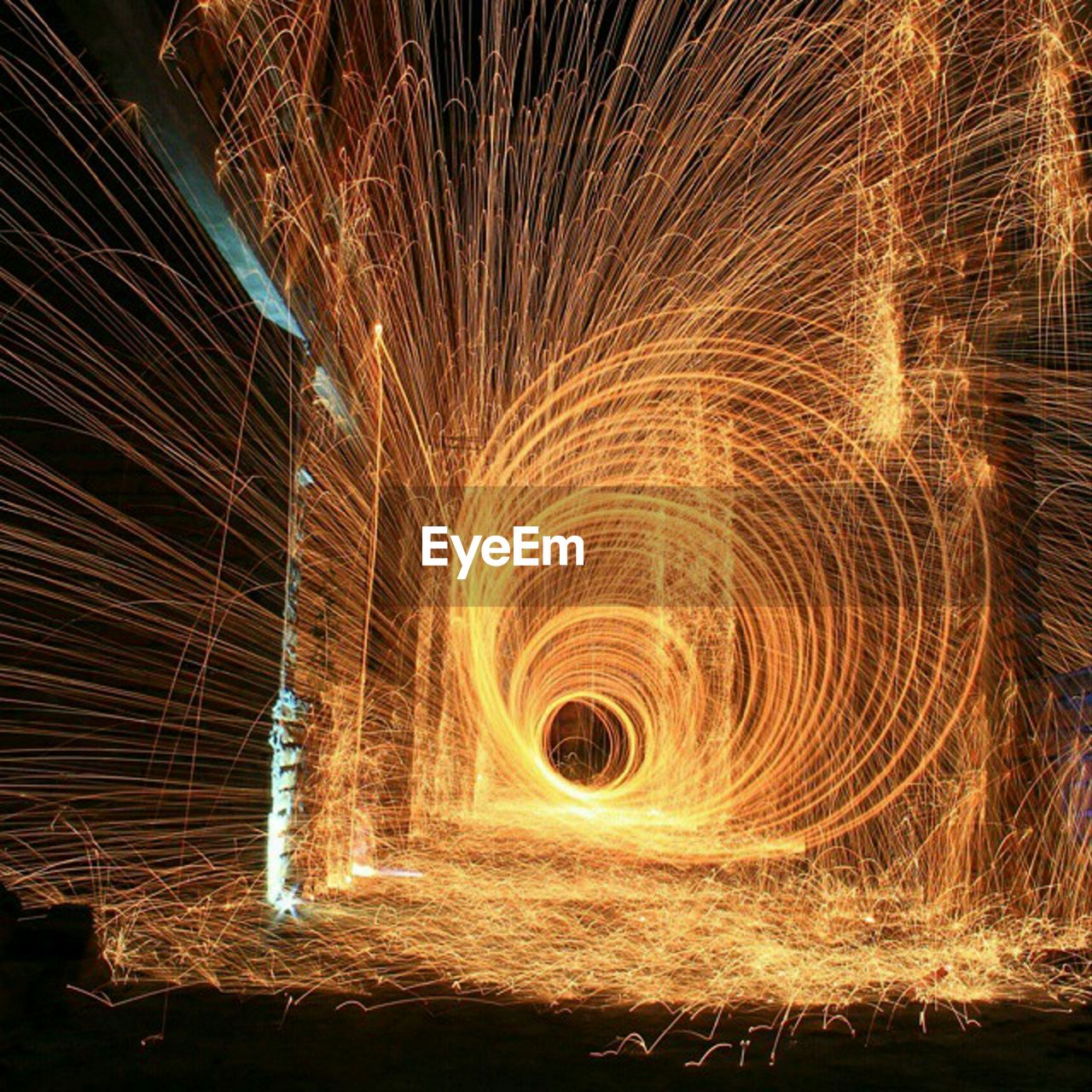 LIGHT TRAILS ON WALL OF FIRE AT NIGHT