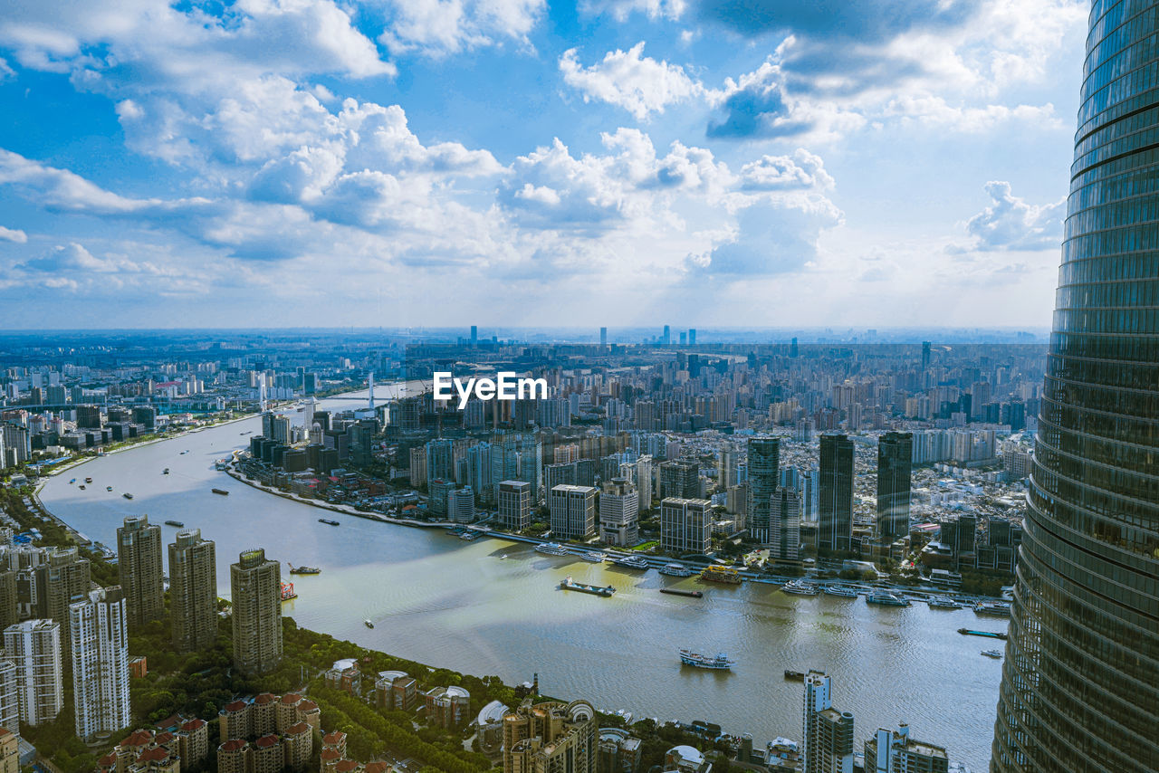 HIGH ANGLE VIEW OF RIVER BY BUILDINGS AGAINST SKY