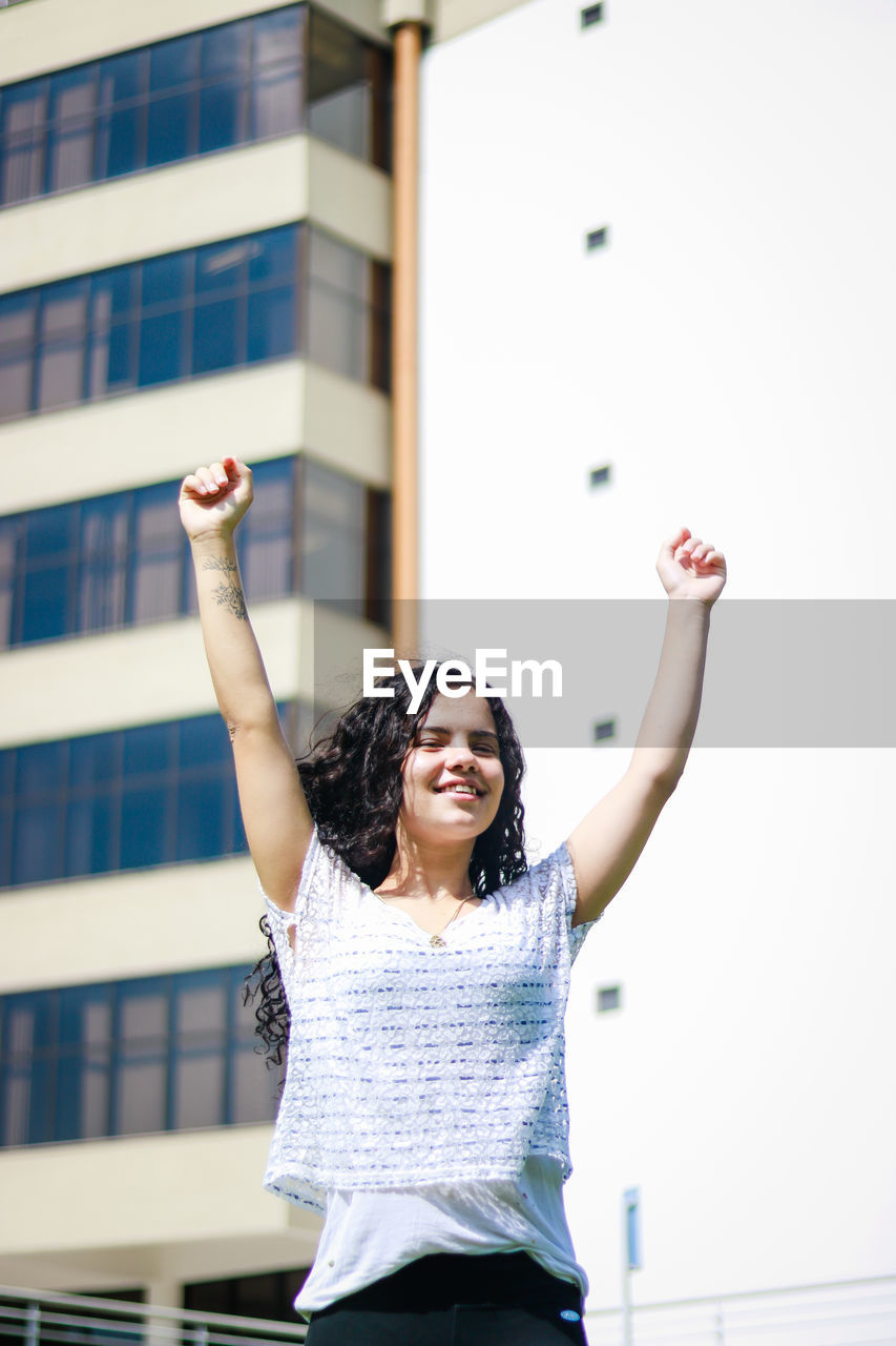 Smiling teenage girl against building in city