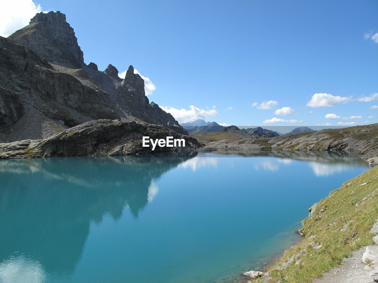 Panoramic view of lake and mountains against blue sky