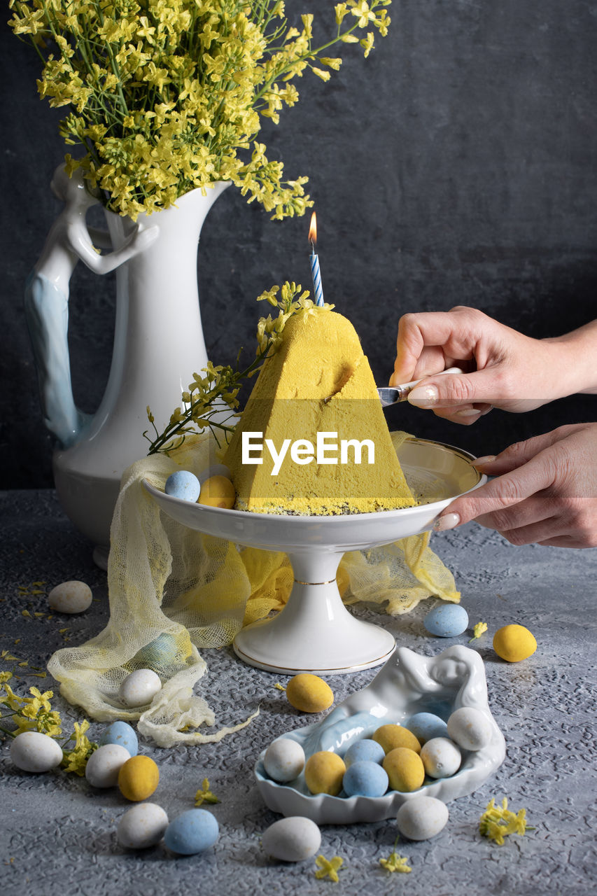 Traditional easter orthodox curd cake with yellow flowers on a grey table