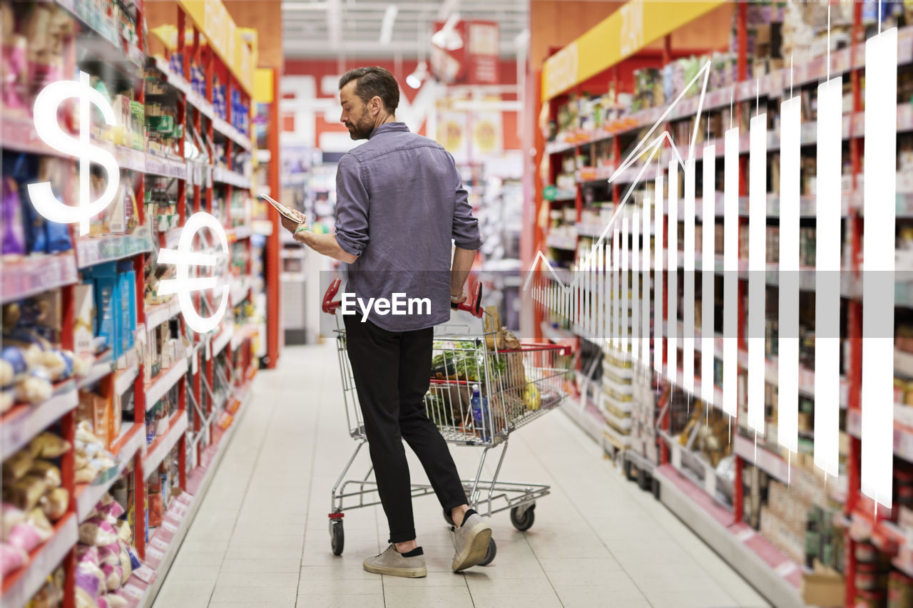 Financial chart and man shopping in supermarket