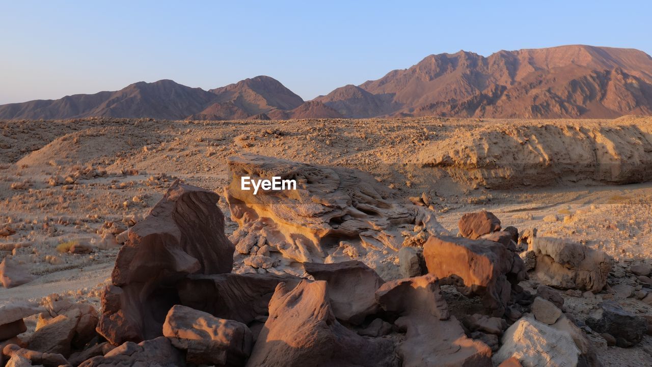 SCENIC VIEW OF ROCKS AND MOUNTAINS AGAINST SKY