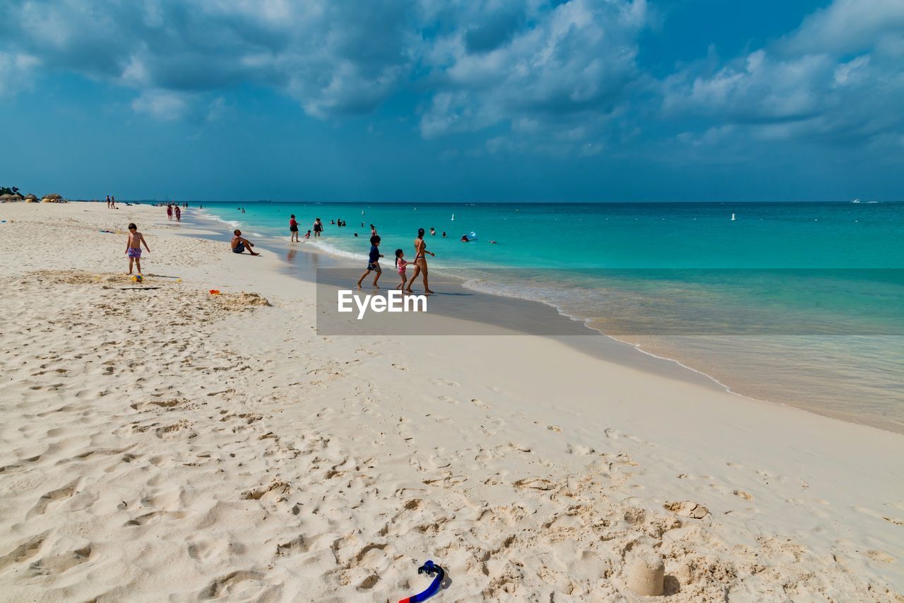 People at beach against sky