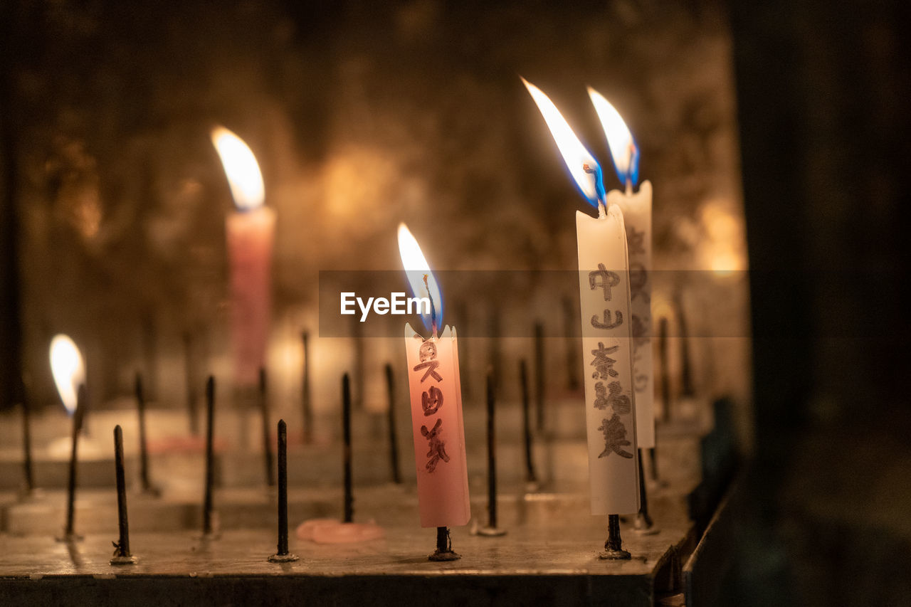 Close-up of lit candles in temple