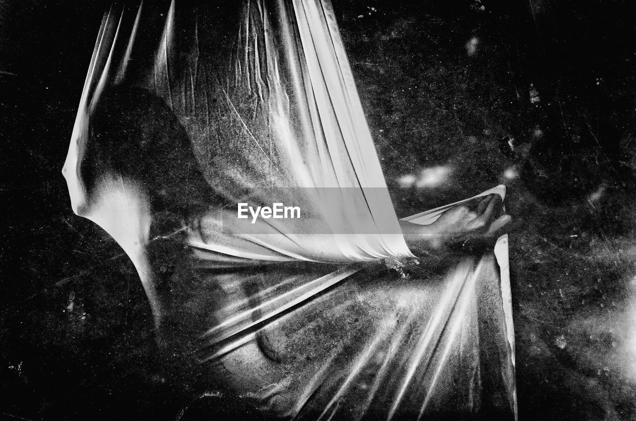 Woman wrapped in curtain in darkroom