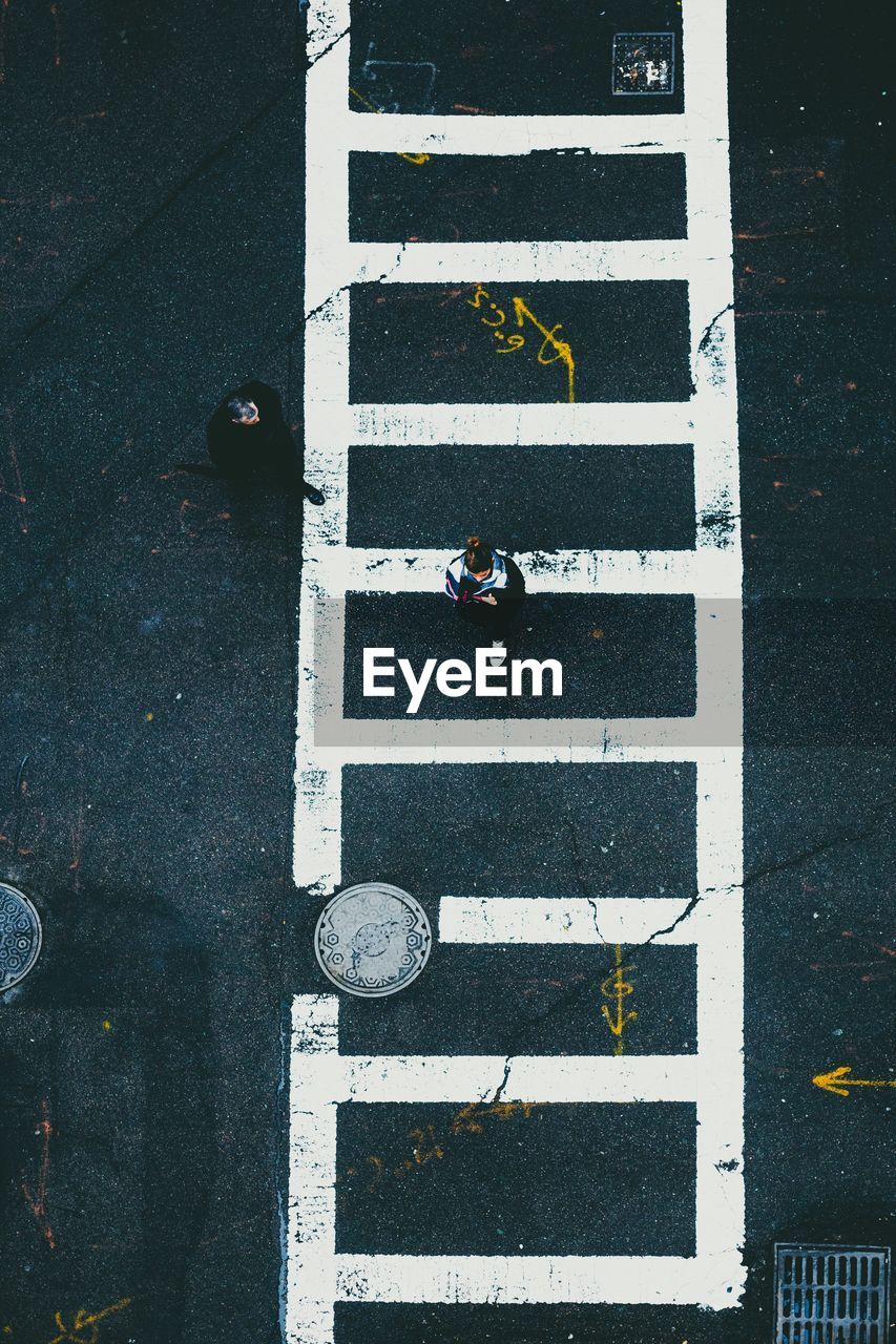 High angle view of woman walking on crosswalk