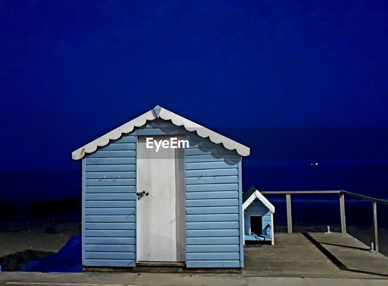 Hut at beach against sky during night