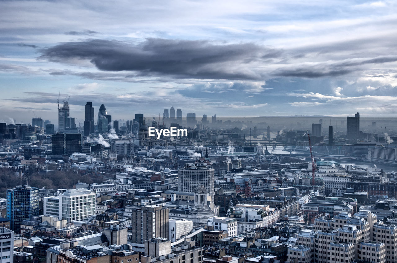 Cityscape against cloudy sky