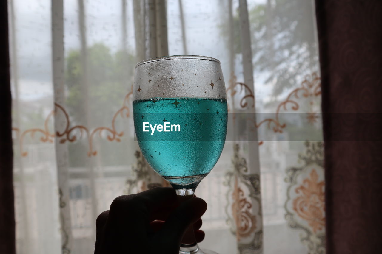 Close-up of woman holding glass of drink