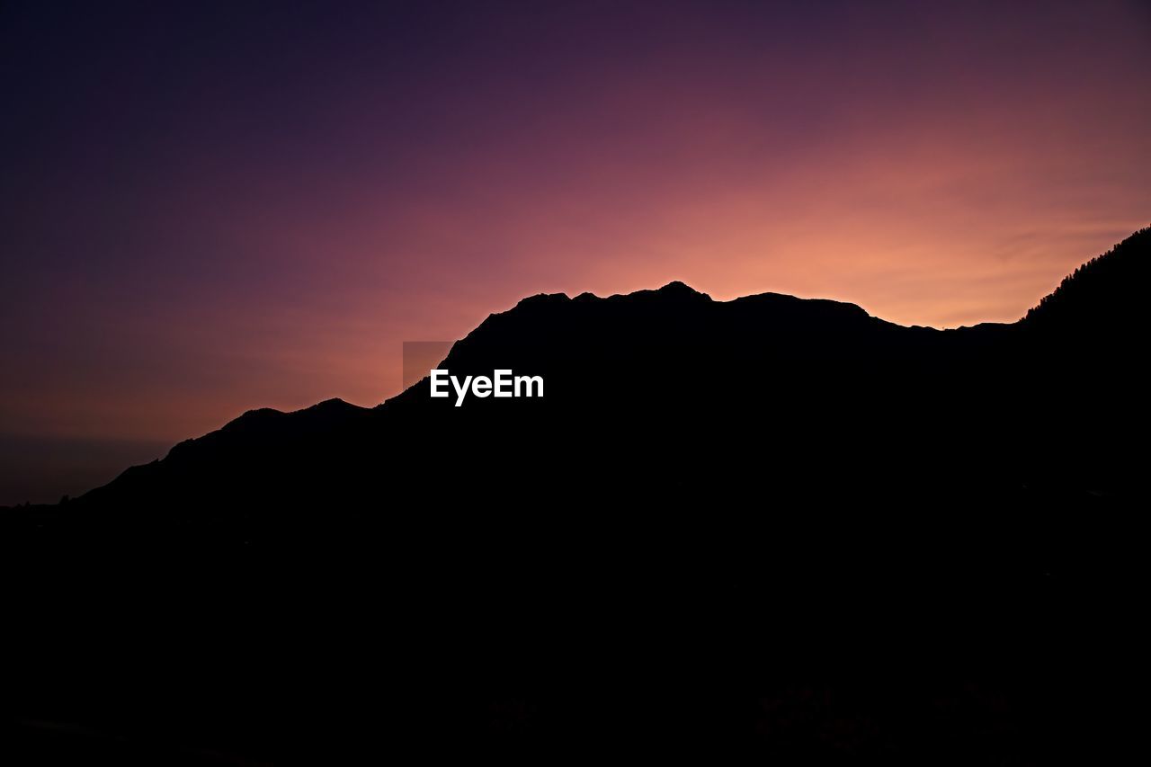 Scenic view of silhouette mountains against sky at sunset