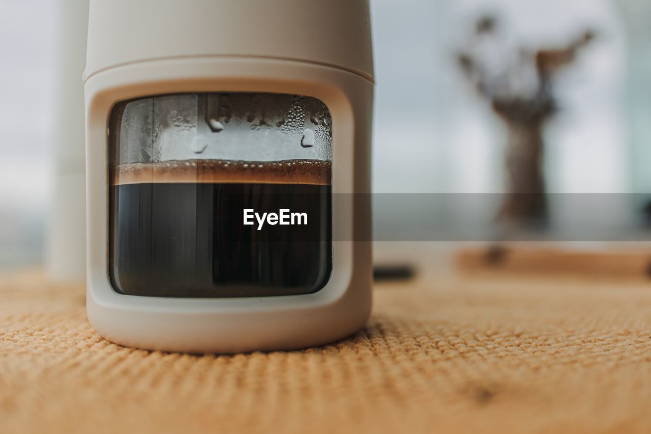 hand, indoors, technology, skin, close-up, human eye, selective focus, table, food and drink, small appliance