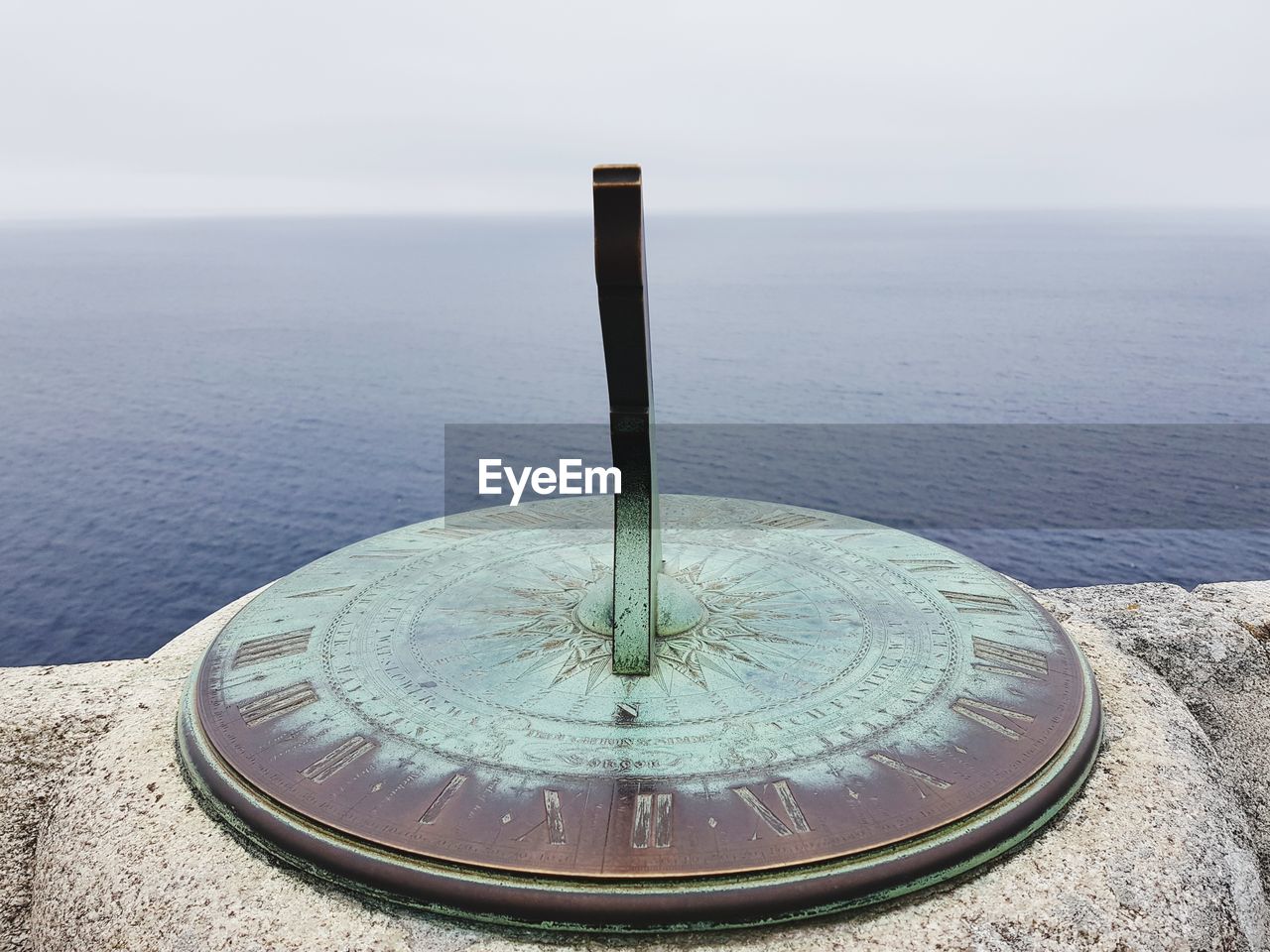 Close-up of metallic structure on sea against sky