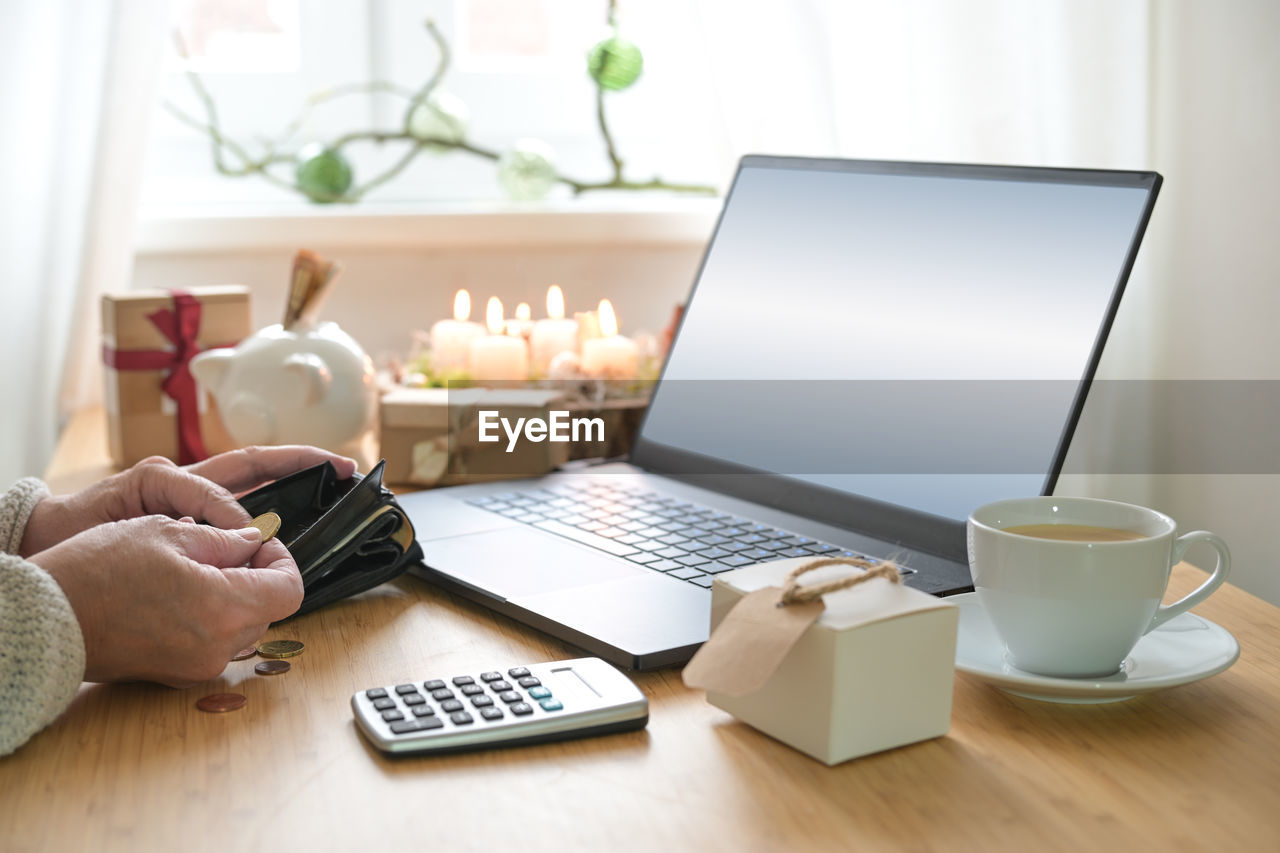 cropped hands of woman using laptop on table