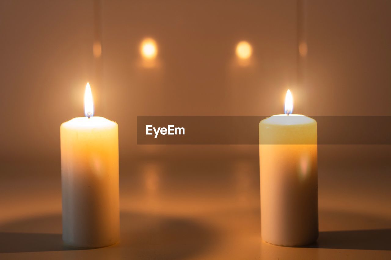 Close-up of illuminated candles on table