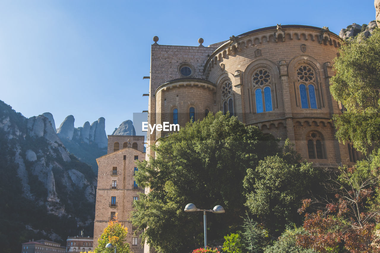 Low angle view of buildings against clear sky at santa maria de montserrat abbey