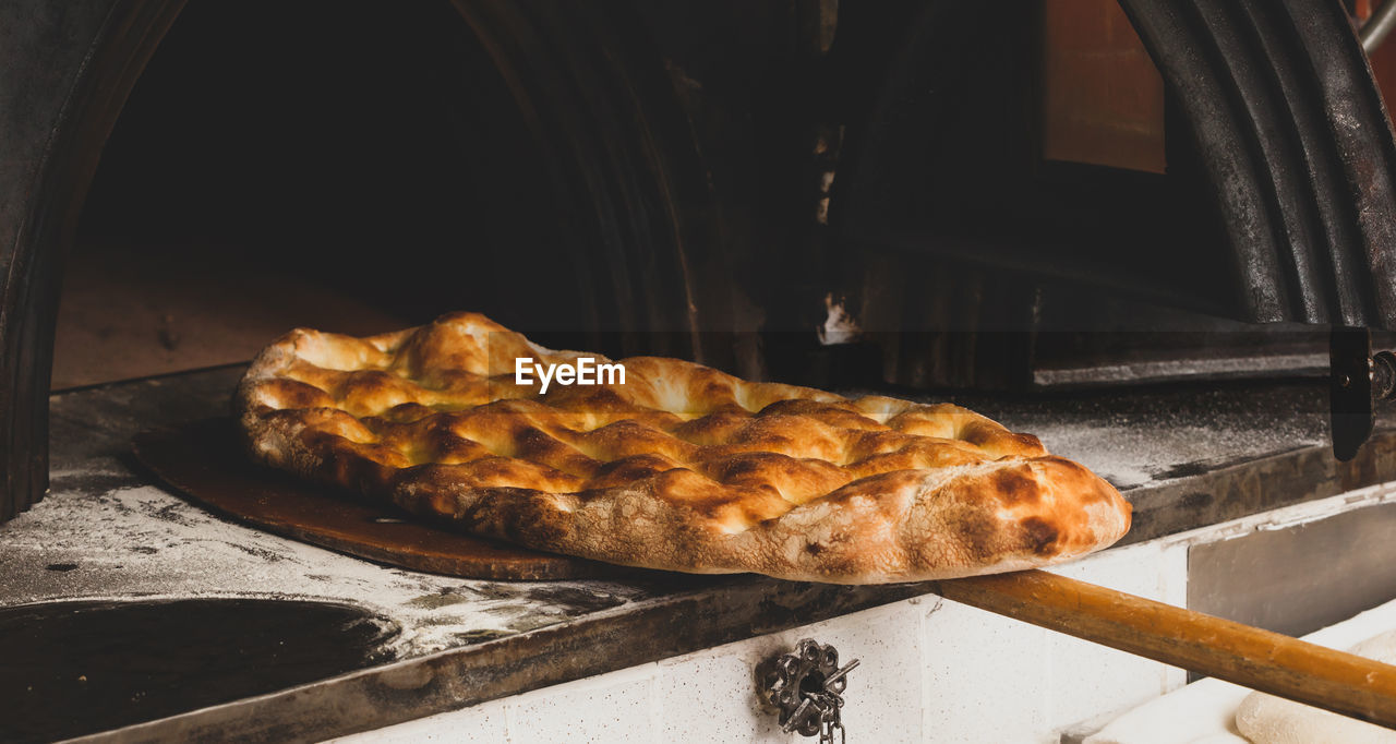 Production of baked bread with a wood oven in a bakery.