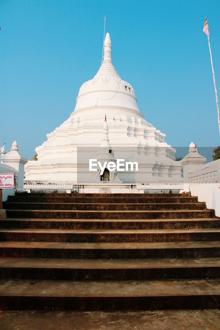 Low angle view of steps of white buddhist temple against blue sky