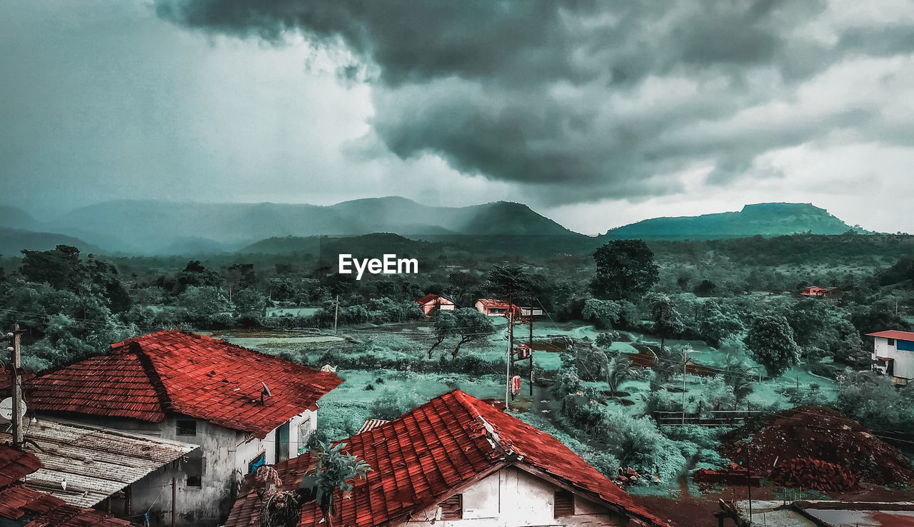 Houses on mountain against sky