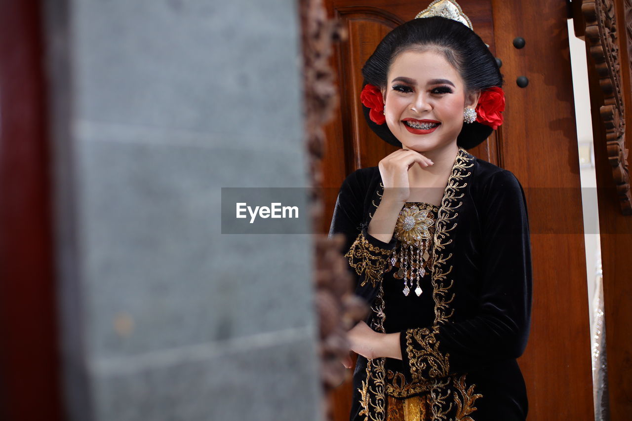 Portrait of smiling young woman standing outdoors