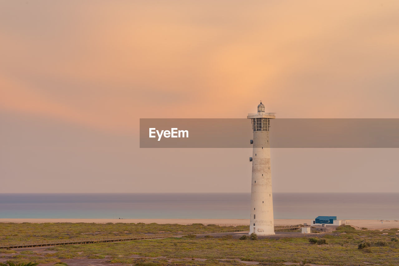 LIGHTHOUSE BY SEA AGAINST SKY