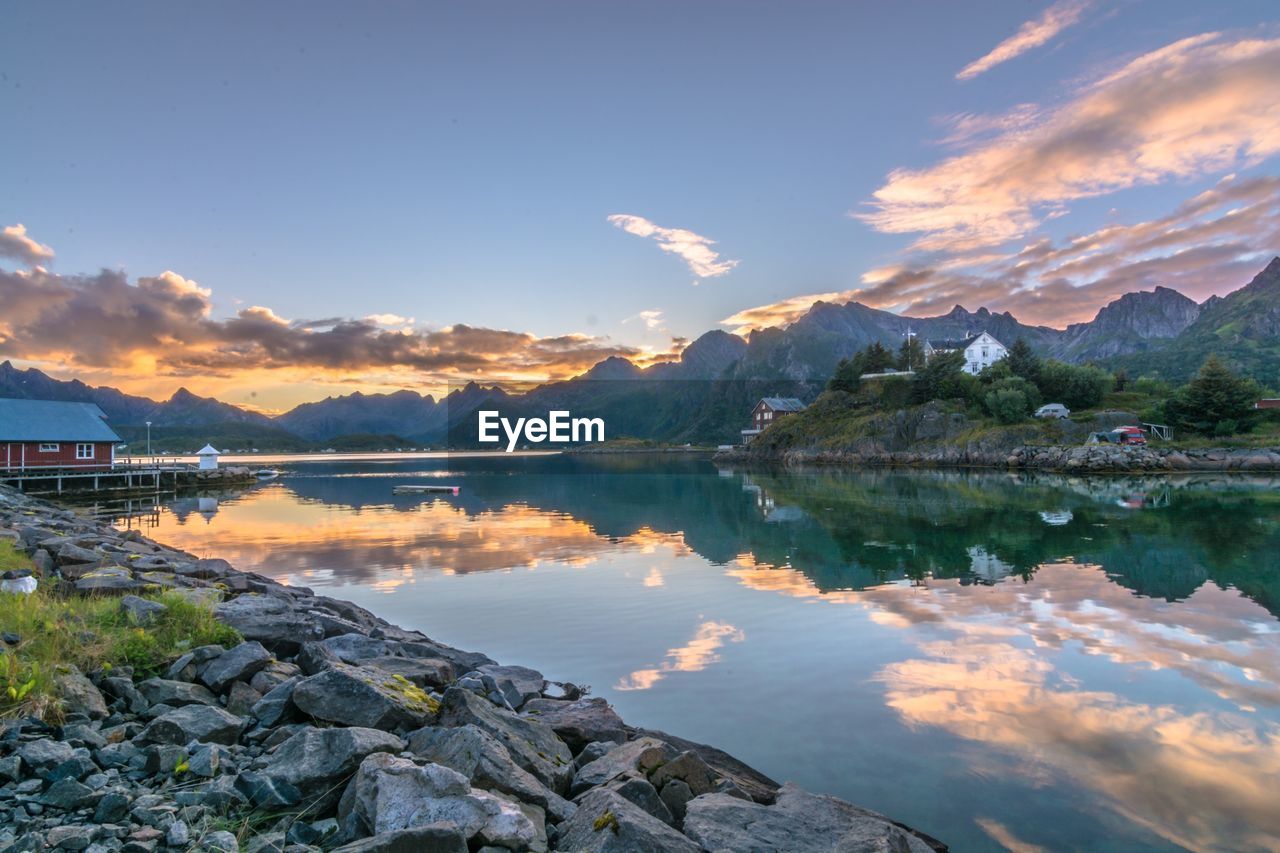 Scenic view of lake by mountains against sky